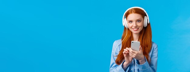 Tender and feminine cute redhead female student wearing headphones study lisening classical music person