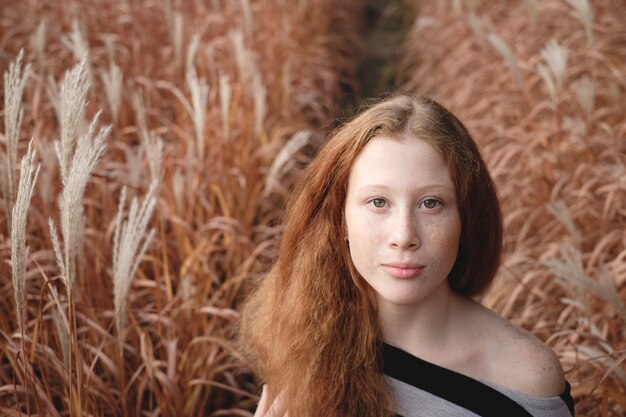 Tender girl feels freedom on the autumn field. Concept of natural look and beauty