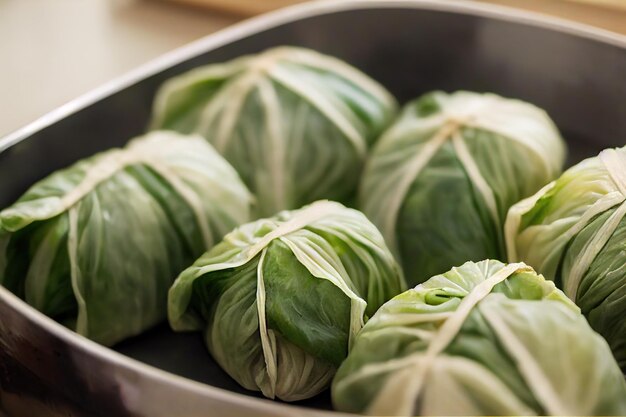 Tender green round stuffed cabbage rolls with meat are on\
platter on table