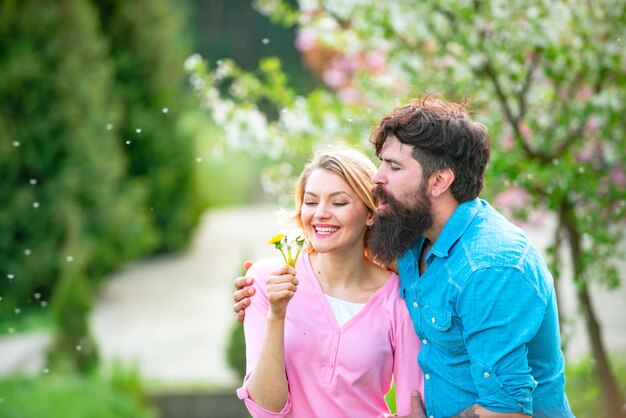 優しい愛情咲く庭の男と女花の咲く木の庭で恋をしているカップルの笑顔