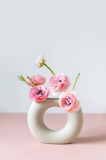 Tender ranunculus flowers in ceramic vase