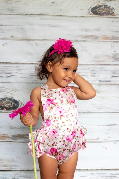 Photo tender smiling toddler, with a flower in her hand