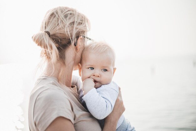 Tender vrouw streelt haar kleine baby jongen baby kind buiten moeders onvoorwaardelijke liefde voor haar