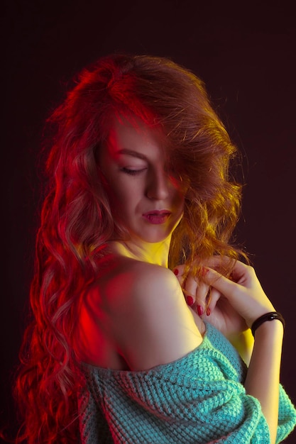 Tender woman with long curly hair in the dark at studio