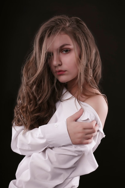 Tender young woman wearing shirt with naked shoulders