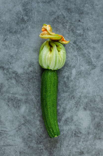 Tender zucchini with flower on a stone background Copy space