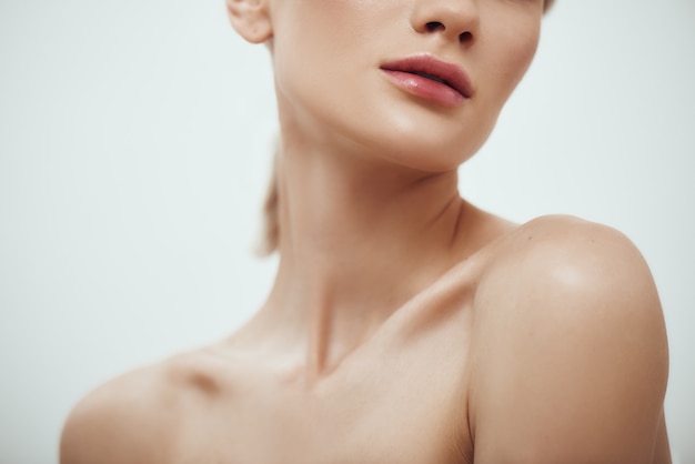 Tenderness and beauty cropped photo of attractive young woman with naked shoulder standing against