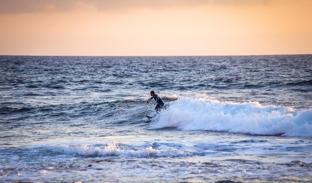 테네리페 카나리아 섬 스페인 2018년 5월 11일 대서양 연안의 플라야 데 라스 아메리카스에서 큰 파도를 타고 서핑을 하는 미확인된 남자