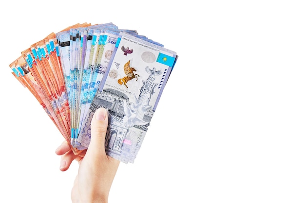 텡게. 여성 손은 흰색 배경 클로즈업에 많은 카자흐어 지폐를 보유하고 있습니다.