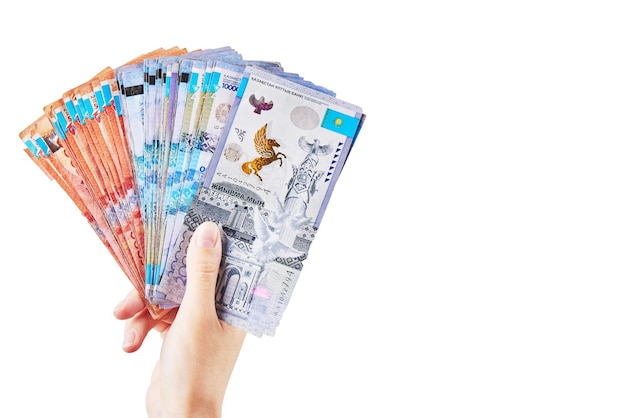 Tenge. The female hand holds many Kazakh bills on a white background close-up.