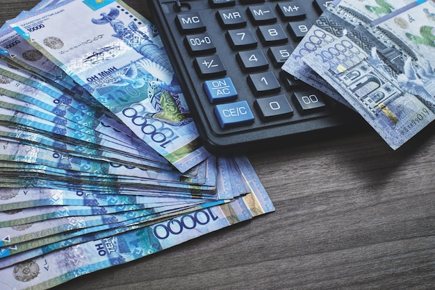 Tenge. Paper Kazakh money and calculator on the table close-up.