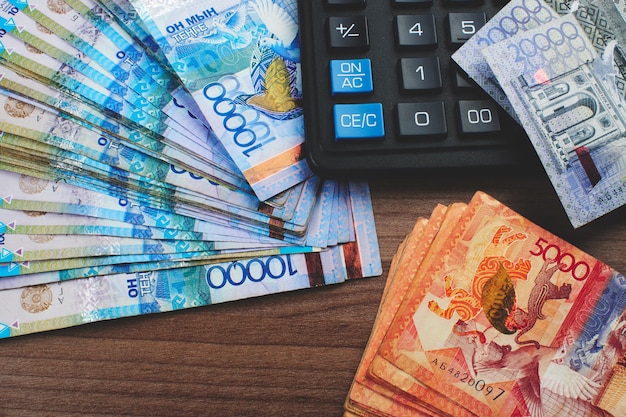 Tenge. Paper Kazakh money and calculator on the table close-up.