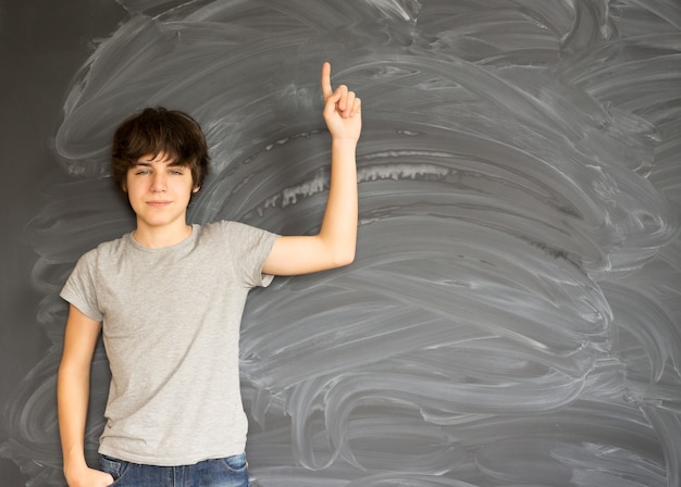 Tennage Boy getting an idea with empty black board in background