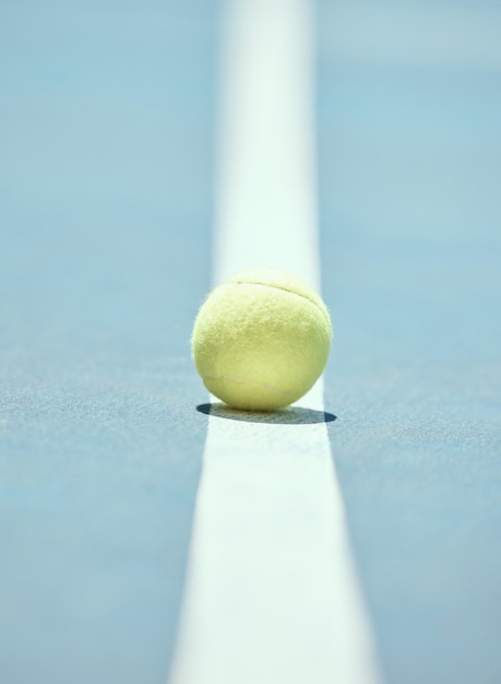 Tennis ball on the floor of a sports court during practice for\
a match in summer outdoors closeup of equipment for athlete team to\
train their strategy and skill for exercise and a game at\
stadium