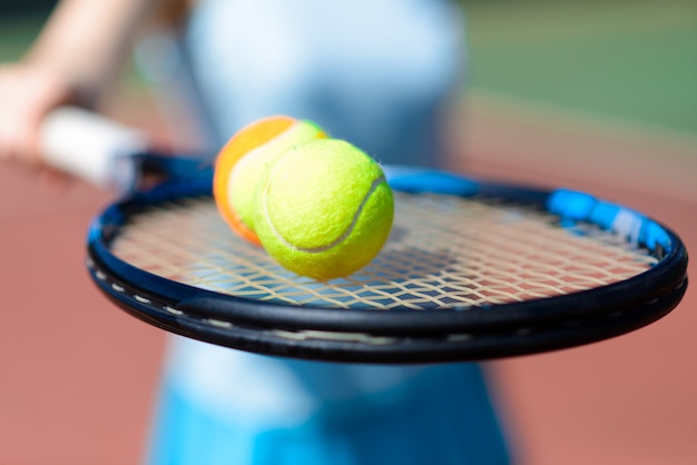 Tennis ball and racket on court field in sunny day