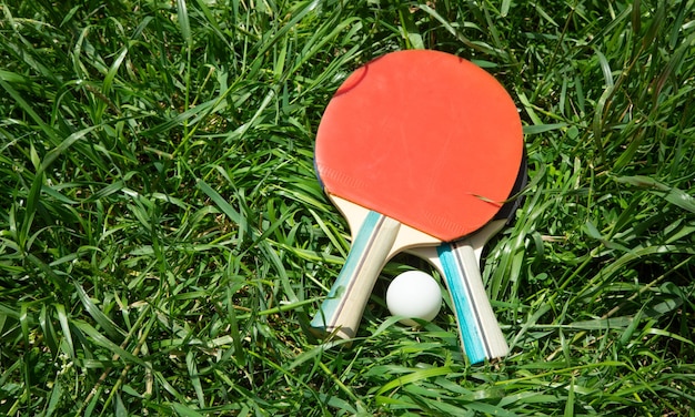 Tennis ball and racket on the green grass background