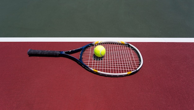 Photo tennis ball with racket on the tennis court.