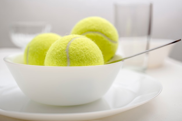 Tennis balls are in a bowl instead of ice cream