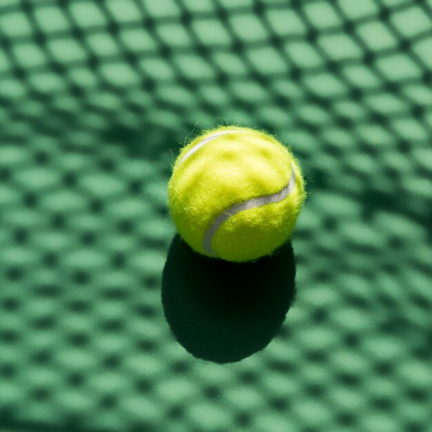 Tennis balls on the field in the net in the shopping basket in hand