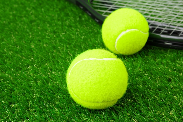 Sfere di tennis sulla fine dell'erba in su. attrezzatura da tennis