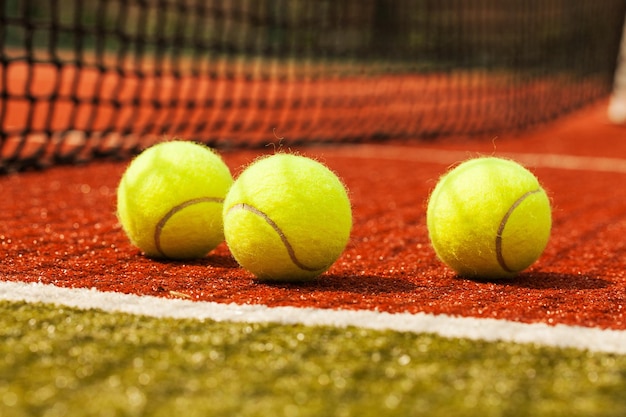 Tennis balls on a red clay court