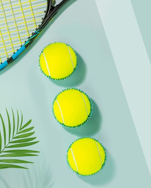 Tennis balls and tennis racket on a blue court background