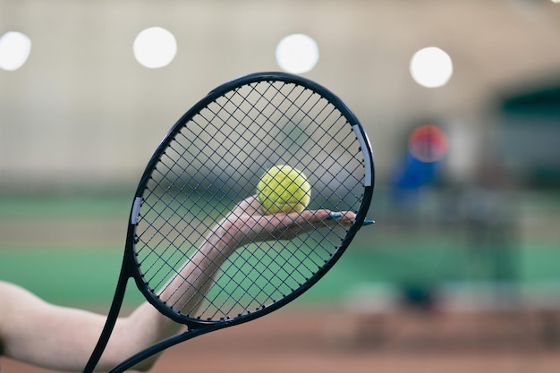 Теннисистка играет в теннис с ракеткой и мячом на корте
