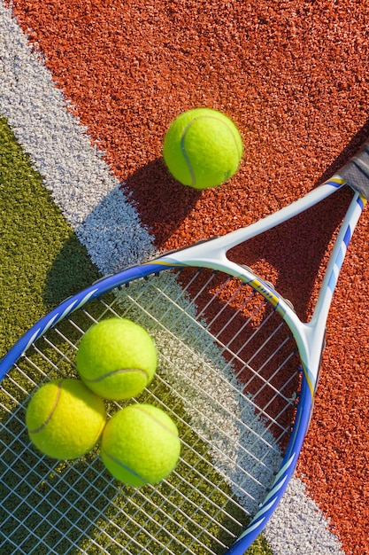 Tennis game. Tennis balls and racket on court background.