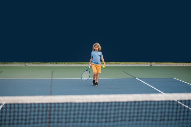 写真 テニス コート上の小さな子供テニス プレーヤーの近くにボールとラケットを持つ全身小さなテニス プレーヤー