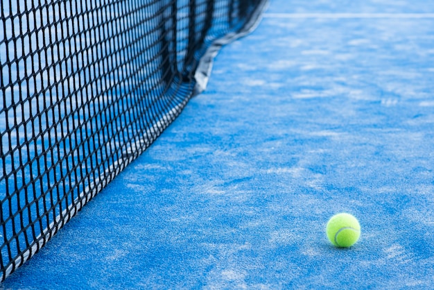 Foto tennis- of peddelbal op de blauwe baan en net