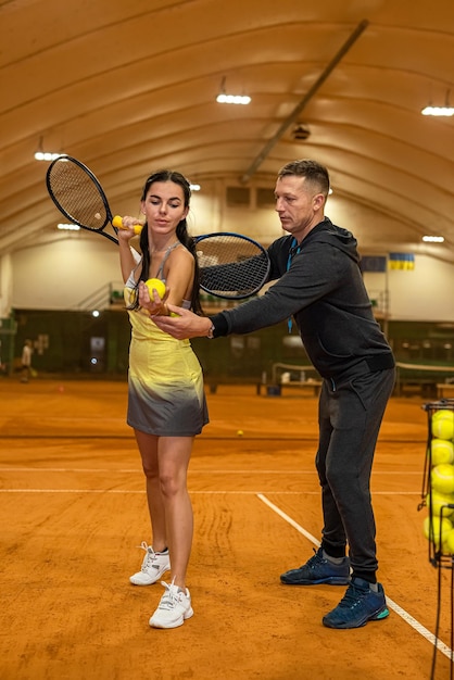 외모가 유쾌한 남자 테니스 선수가 테니스를 배우는 법을 가르치고 있다