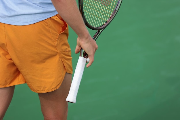 Photo tennis player with racket walking on the court