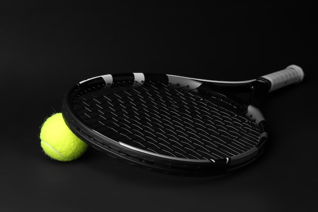 暗い背景にテニス ラケットとボール