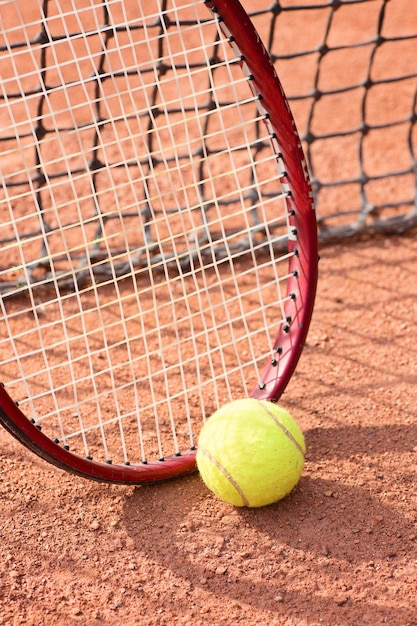 Tennis racket and balls on the clay court