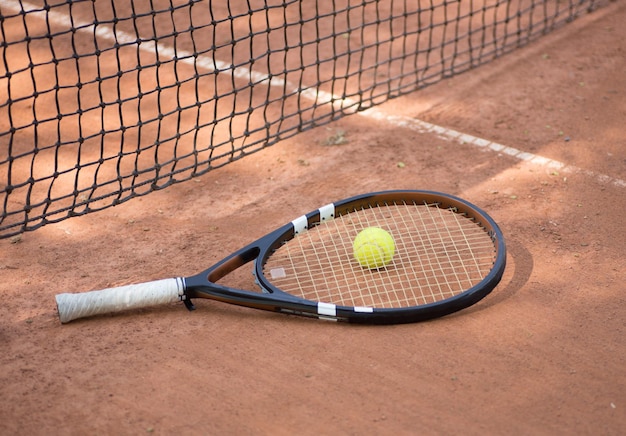 Tennis racket and balls on the clay court