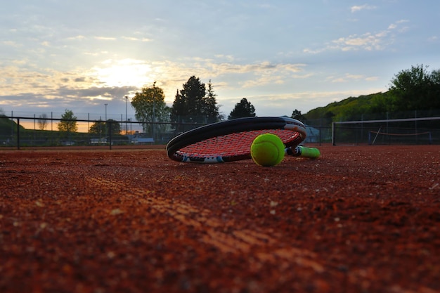 Foto racchetta da tennis sul campo contro il cielo durante il tramonto