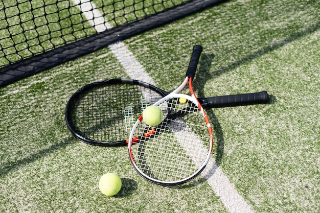 A tennis racket and new tennis ball on a freshly painted tennis
court