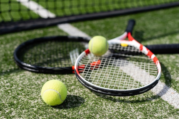 Una racchetta da tennis e una nuova pallina da tennis su un campo da tennis dipinto di fresco