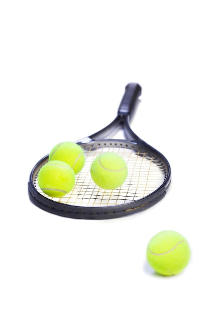 Tennis racket with yellow balls on white background