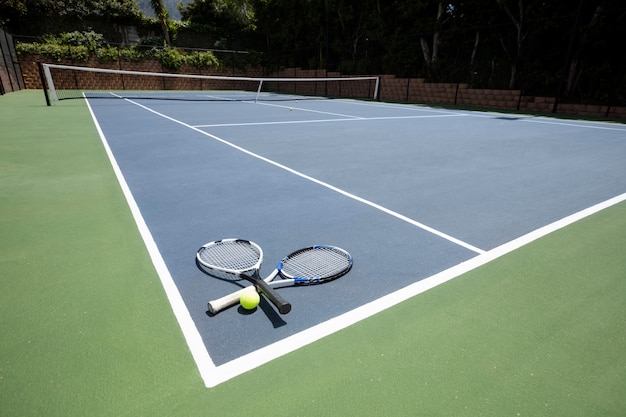 Tennis racquets and ball in court