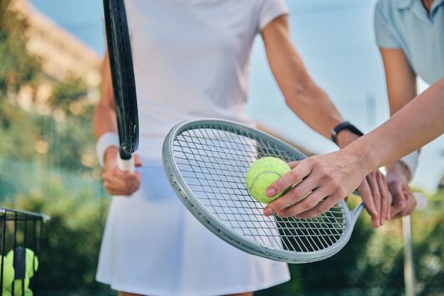 Tennis training hands and ball with women and athlete on outdoor turf instructor or coach fitness motivation and help Exercise sports lesson and workout together teaching and learn on court