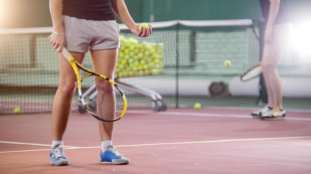 Tennis young men hitting the ball from the floor