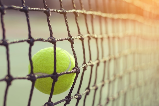 Tennisbal die netto op de achtergrond van het onduidelijk beeldtennisbaan raken