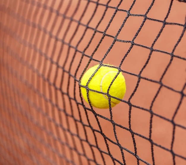 Tennisbal die tegen het net slaat