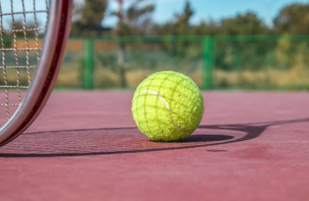 Tennisbal en racket op de baan