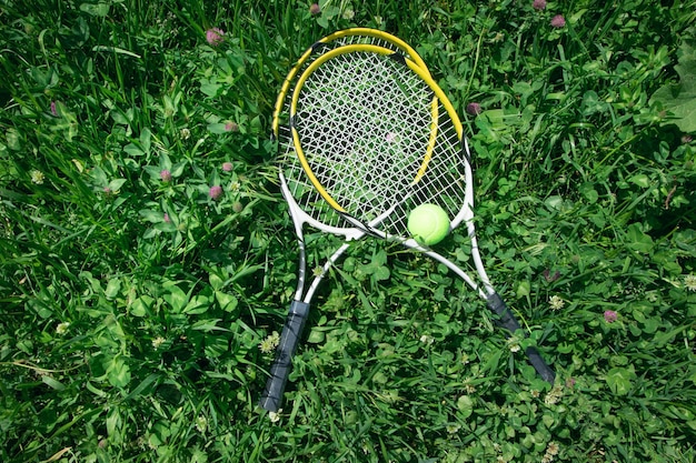 Tennisbal en racket op de groene grasachtergrond