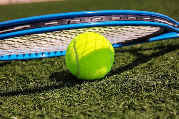 Foto tennisbal en racket op vers groen gras buiten