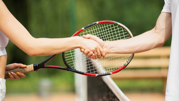 Tennispaar het schudden handenclose-up