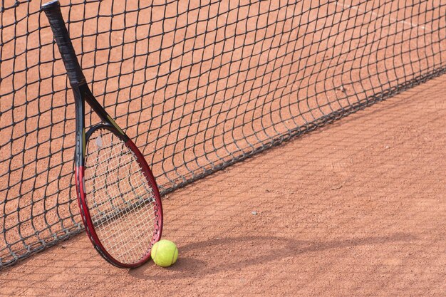 Tennisracket en ballen op de gravelbaan