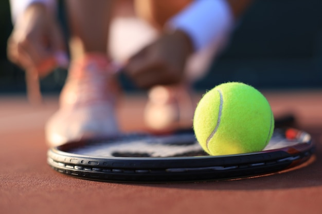 Tennisracket en de bal op de tennisbaan.